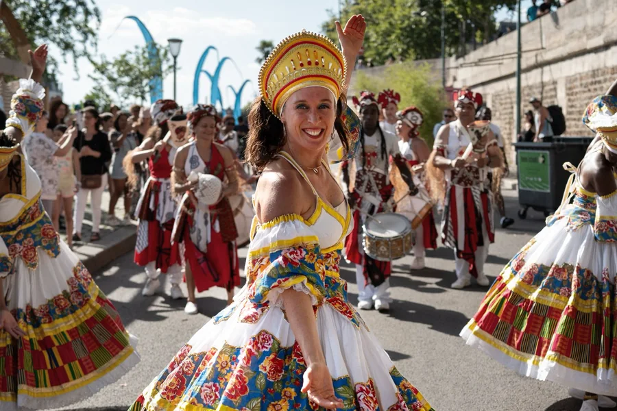 Anaïs de Lattre David dansant en tête du cortège, en robe de baiana et couronne dorée