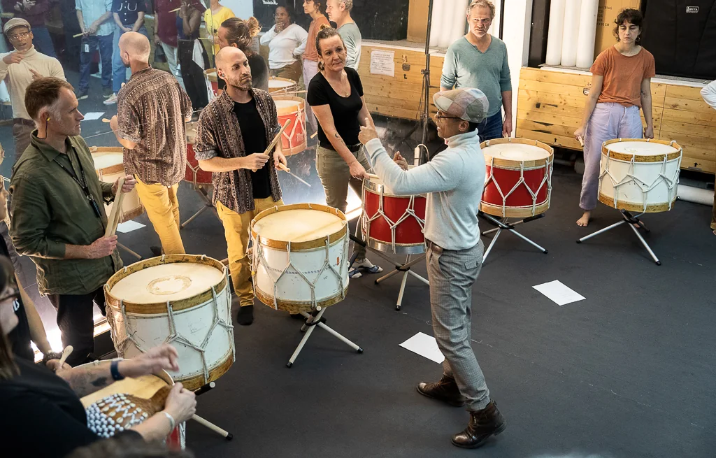 Un atelier Batiboom en entreprise : les participants jouent des alfaias, guidés par Mestre Letho
