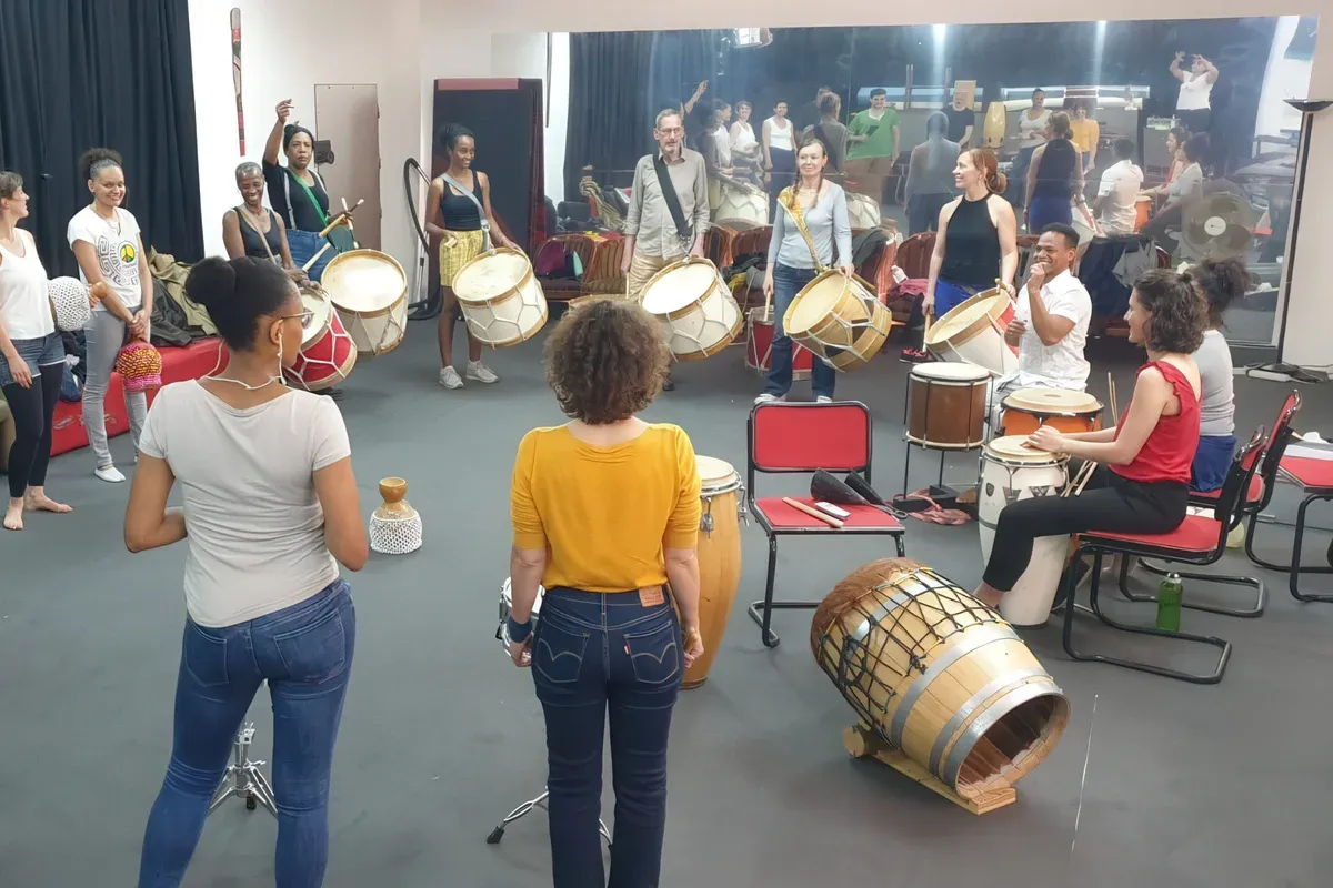 Le groupe en cercle pendant un atelier de percussions, avec les alfaias et les autres instruments