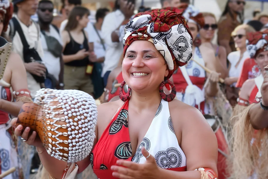 Sandra Dias en défilé, agbê en main, turban rouge et blanc